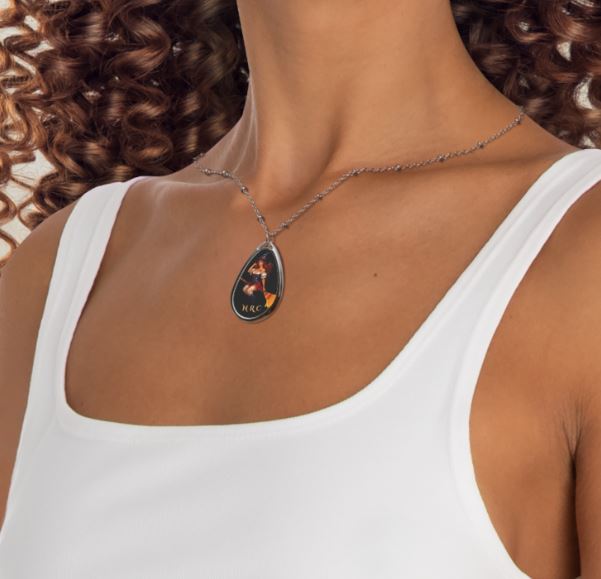 Stylish witch pendant necklace displayed on model featuring glossy teardrop design and NRC branding